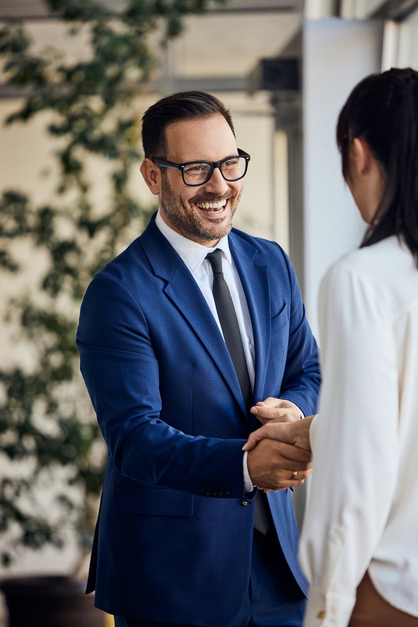 Business professionals engaged in a friendly handshake, showcasing cooperation and teamwork.