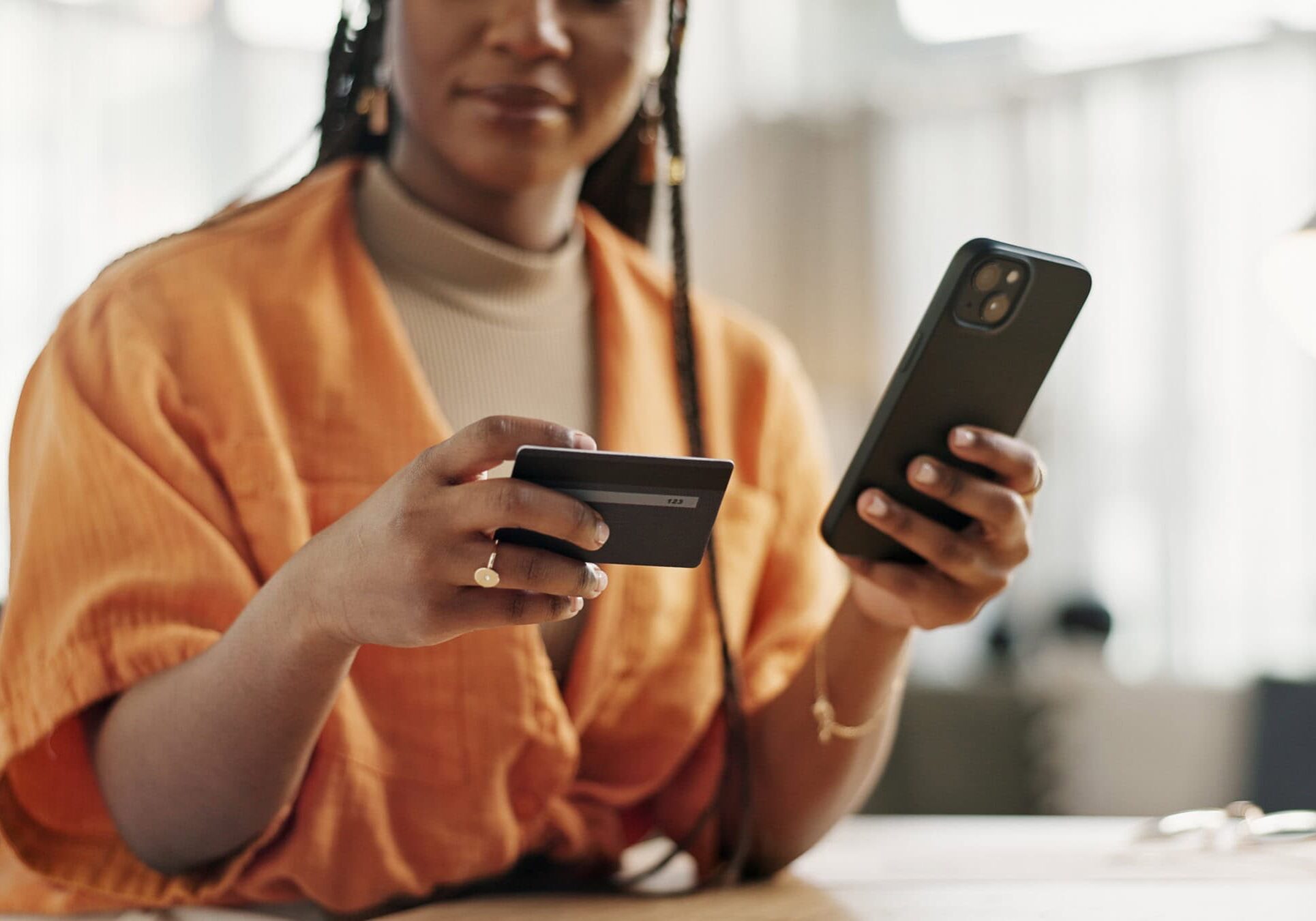 a person or woman using homeowner resources to make an online payment with smartphone and credit card